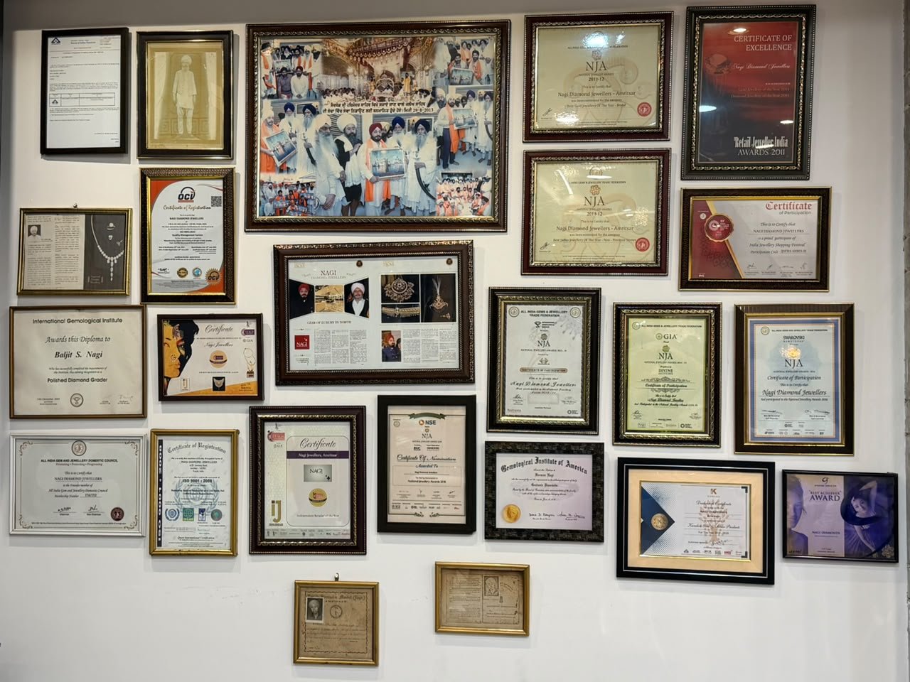 Wall of framed awards and certificates at the Nagi Jewellers showroom