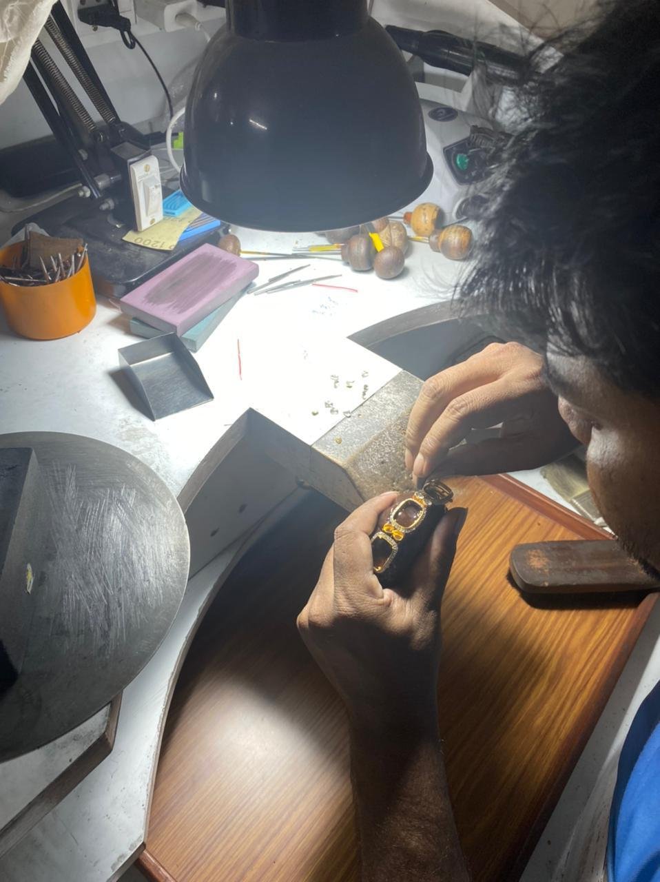 Craftsman setting stones into a bracelet