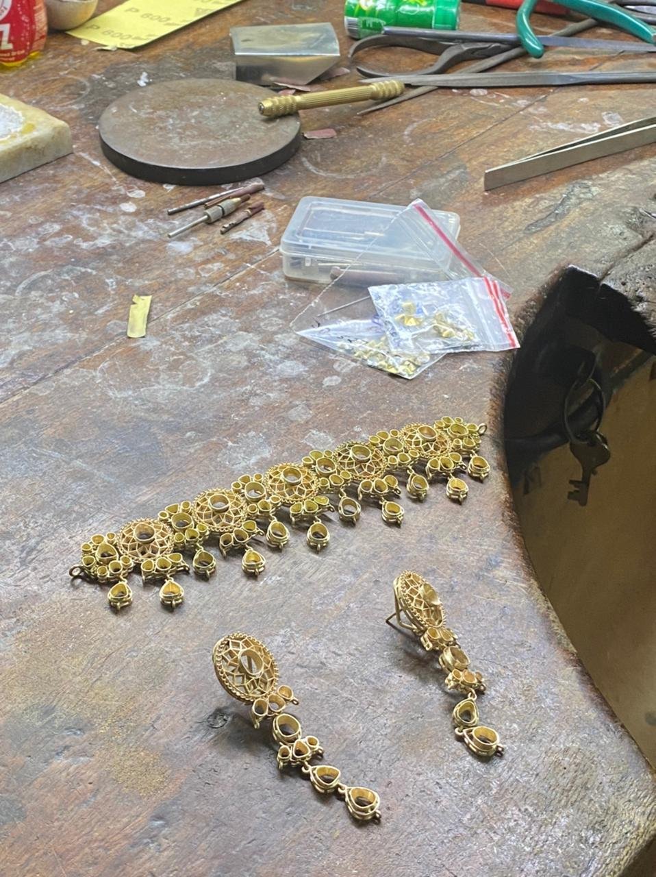 Gold necklace and earring frames on a workbench