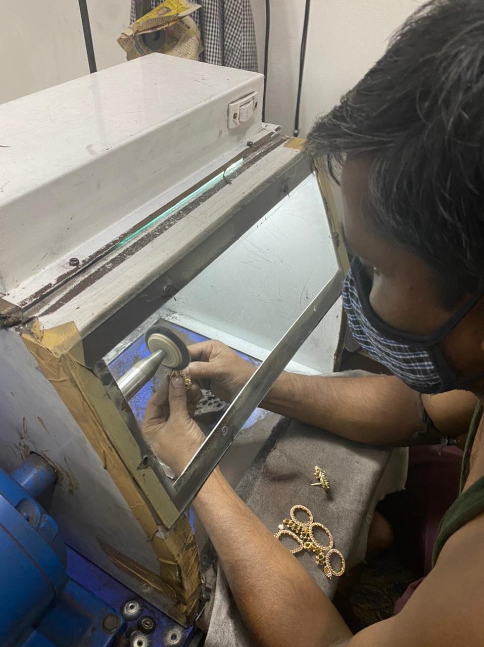Craftsman polishing a jewellery piece on a polishing wheel