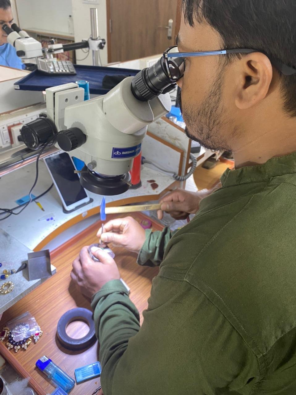 Craftsman working on a piece under a microscope